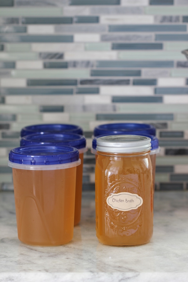 Homemade chicken broth in a jar and containers