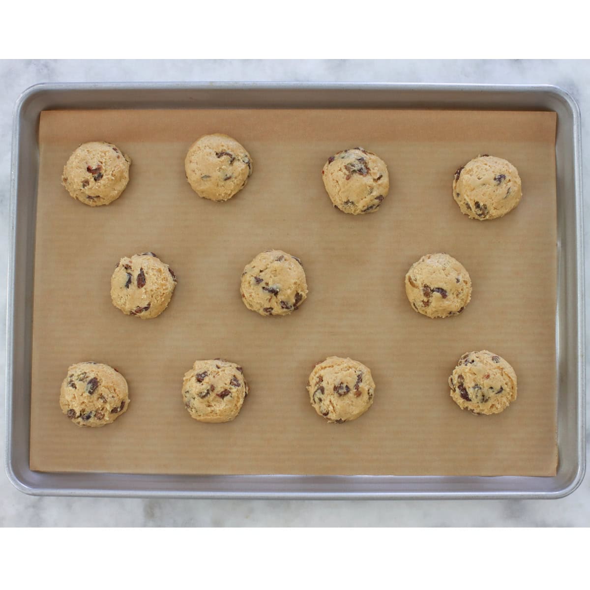 Soft Raisin cookie dough on a rimmed baking sheet before baking.