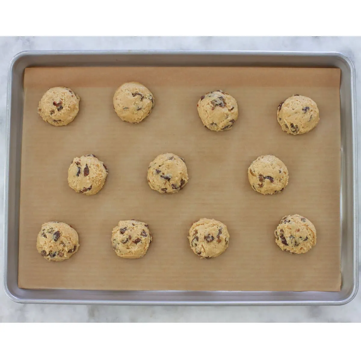 Soft Raisin cookie dough on a rimmed baking sheet before baking. 