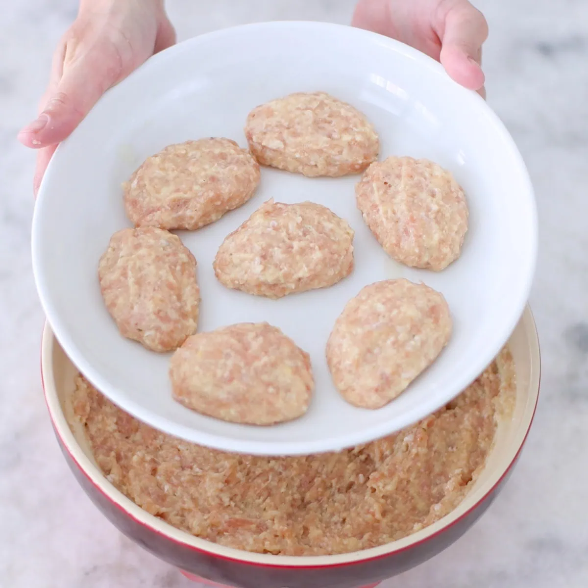 Oval shaped chicken kotleti on a plate before cooking. 