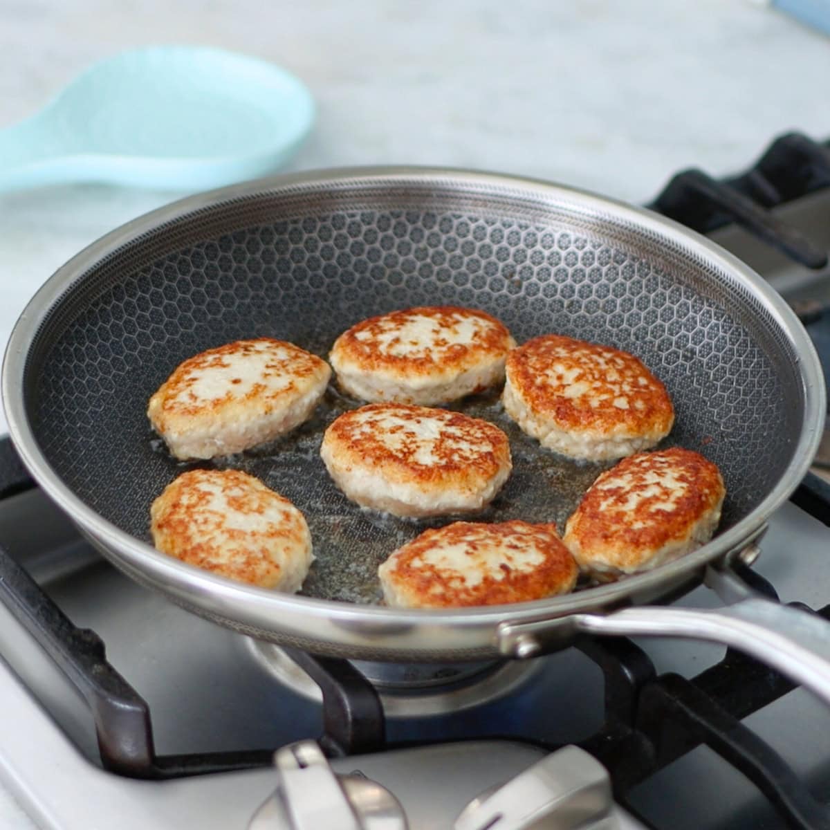 Chicken kotelti cooking in a pan. 