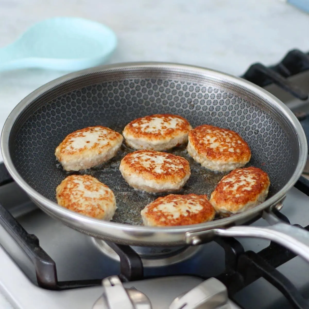 Chicken kotelti cooking in a pan. 