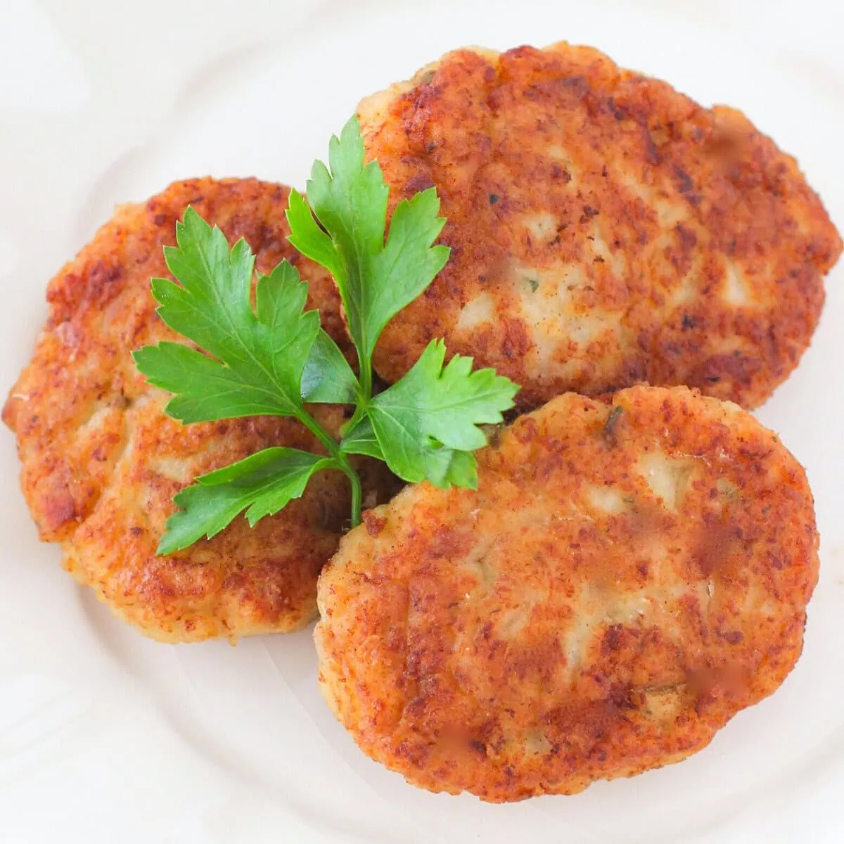 3 chicken kotleti on a plate with parsley.
