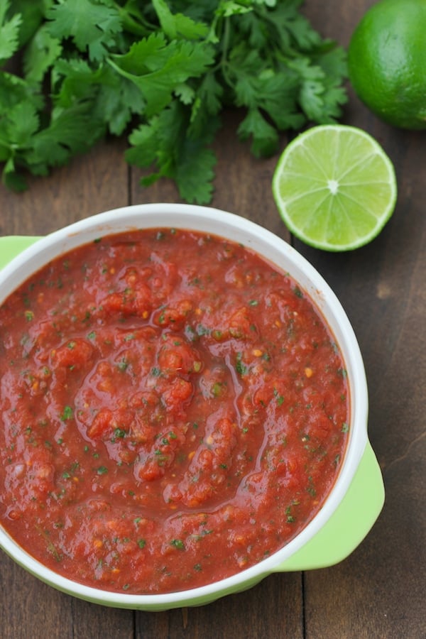 salsa maker squeezes tomatoes to produce traditional home-made sauce