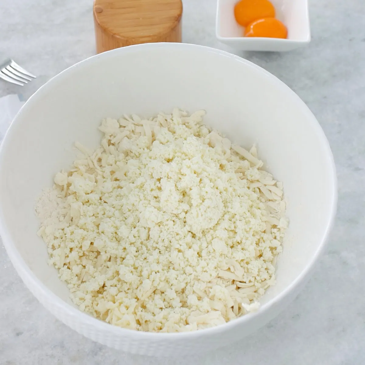 Farmer's cheese in a large bowl to make cookie dough. 
