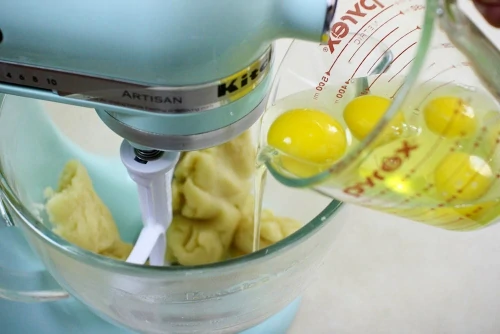 Adding eggs one at a time to pate a choux dough (2)