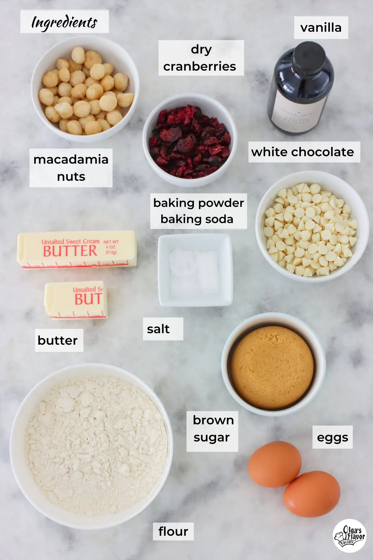 Ingredients for white chocolate macadamia nut cookies bars on a marble counter.