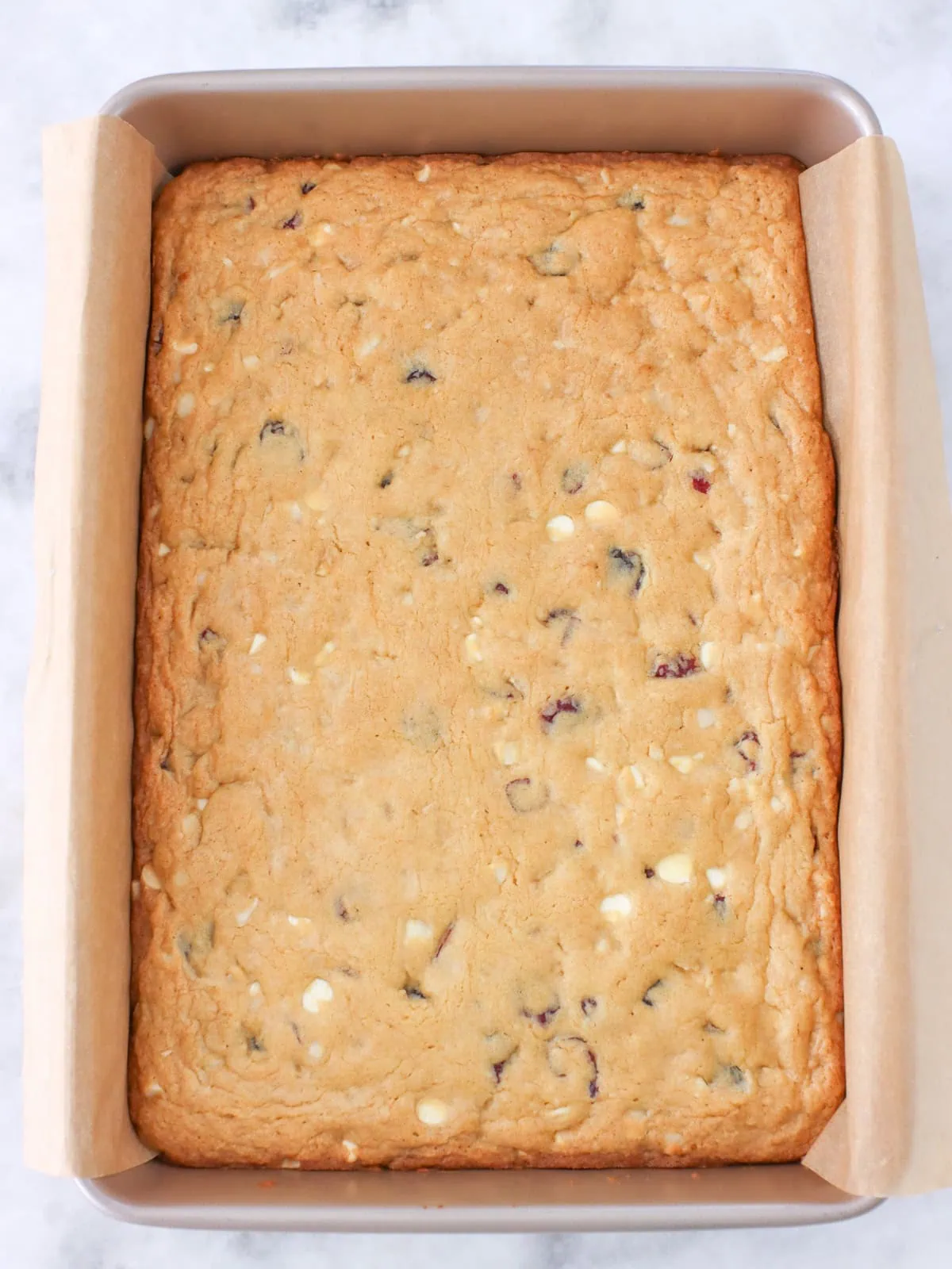 White chocolate macadamia nut cookie bars (blondies) in a baking pan, baked.