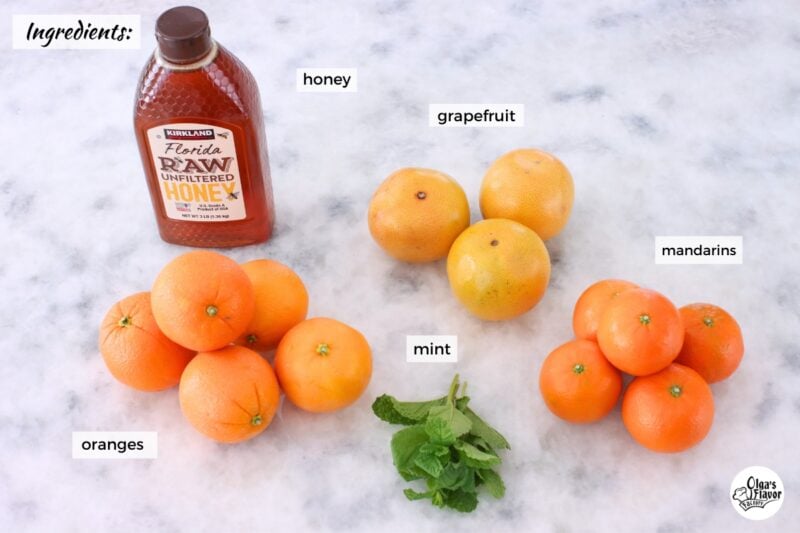 Ingredients for citrus fruit salad, made with oranges, grapefruit, mandarins, honey and mint