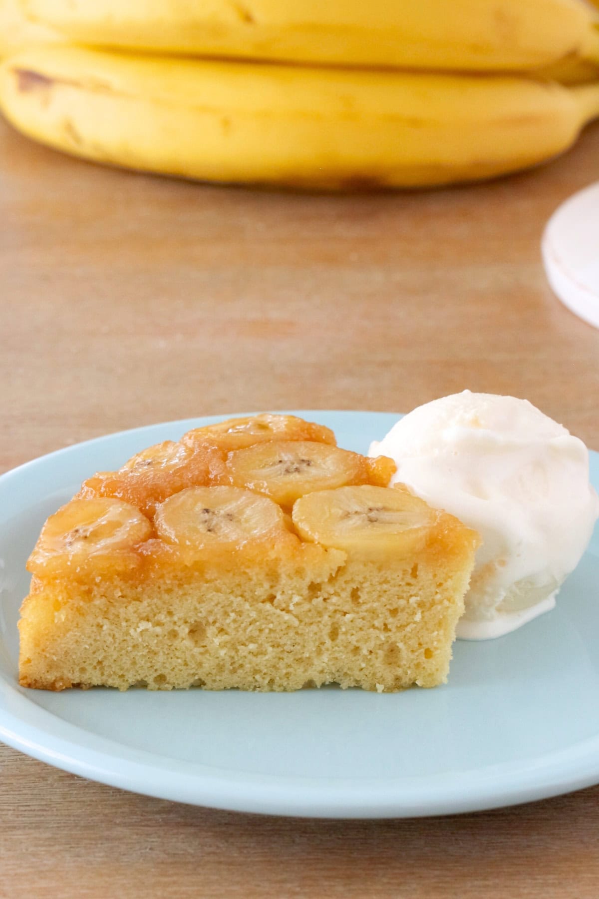 Banana upside down cake - slice of cake on a plate with a scoop of vanilla ice cream.