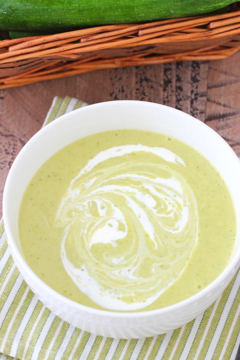 Easy creamy zucchini soup, garnished with swirls of cream.