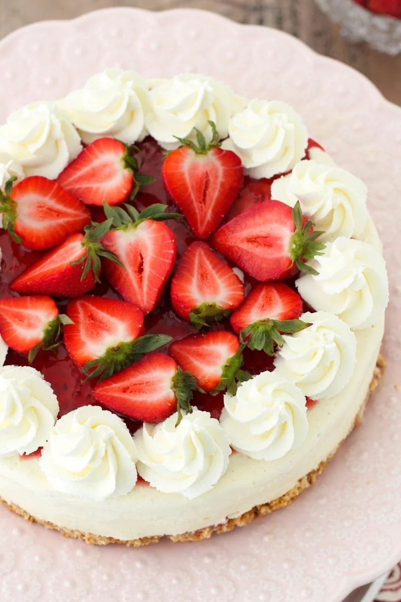 Ice Cream Cake topped with strawberry jam, fresh strawberries and whipped cream