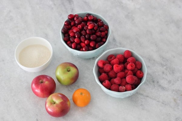 Ingredients for Cranberry Raspberry Kompot on a marble counter. 