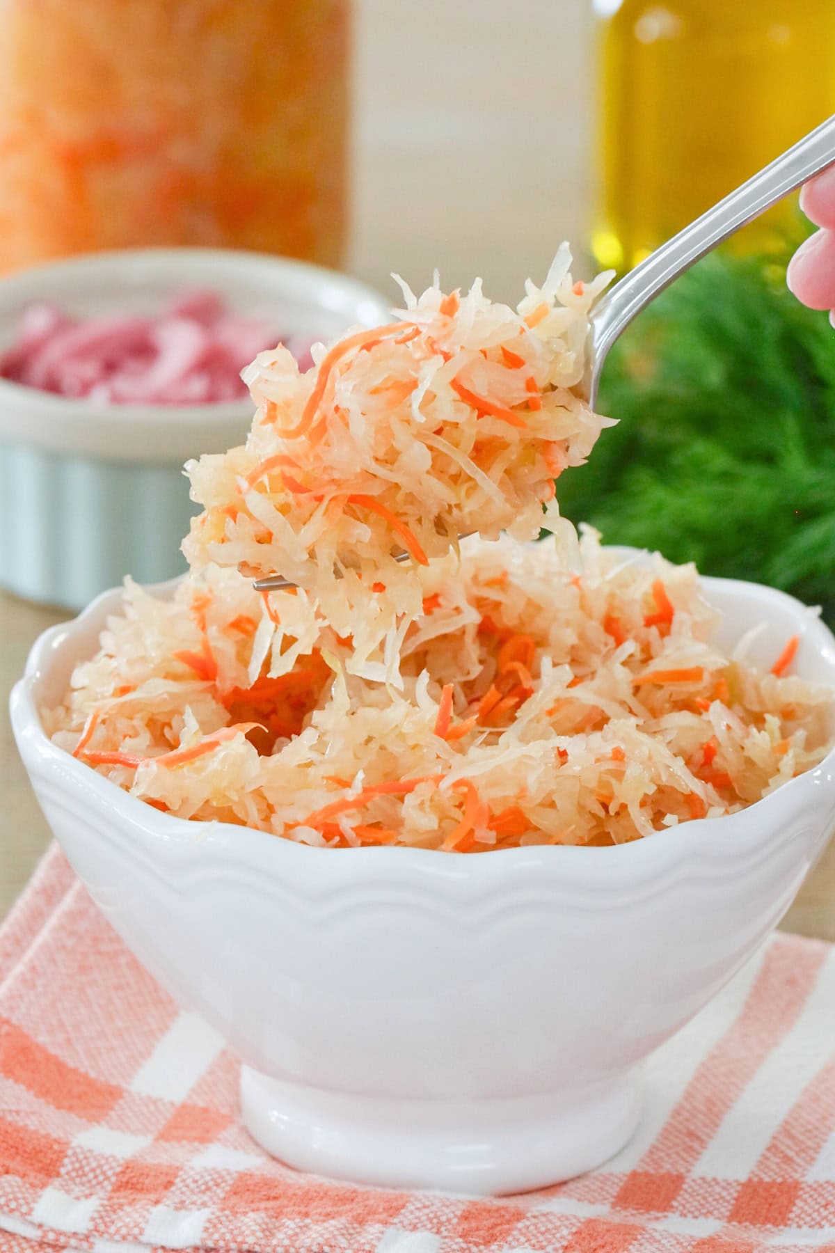 A forkful of homemade sauerkraut in a serving bowl.