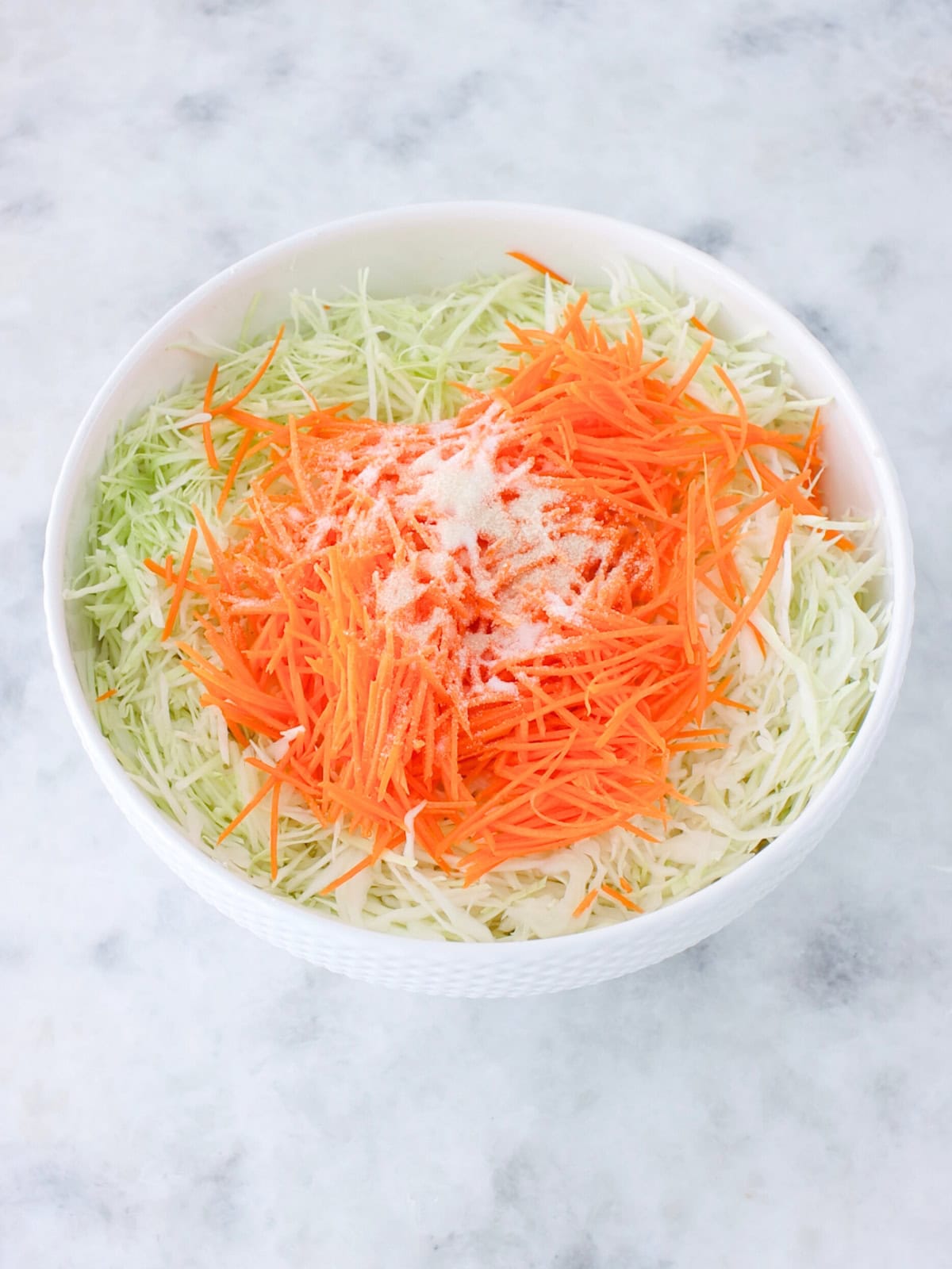 Cabbage, grated carrots, salt and sugar in a large bowl.