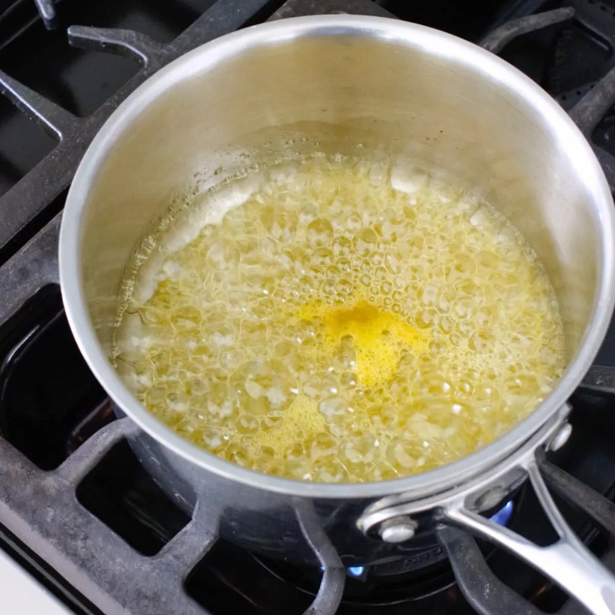 Making an orange lemon syrup/glaze in a small saucepan on the stove. 
