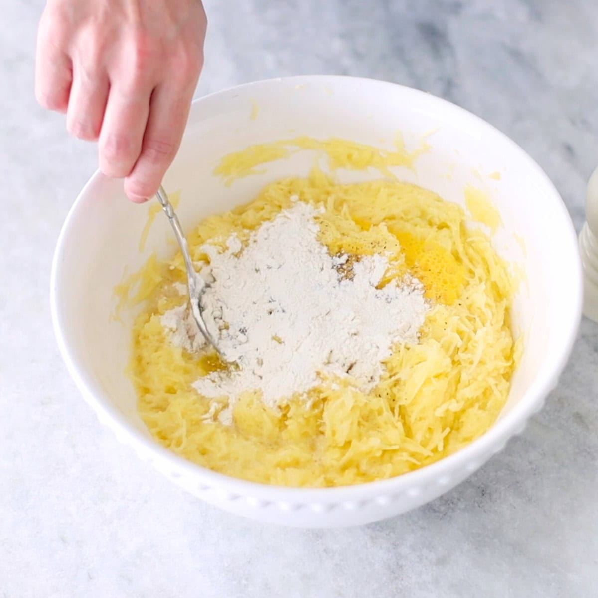 Potato waffle batter in a bowl, mixing together all the ingredients. 