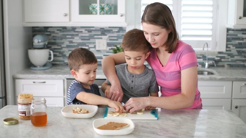 Mom and kids preparing lunch peanut butter and honey sandwiches