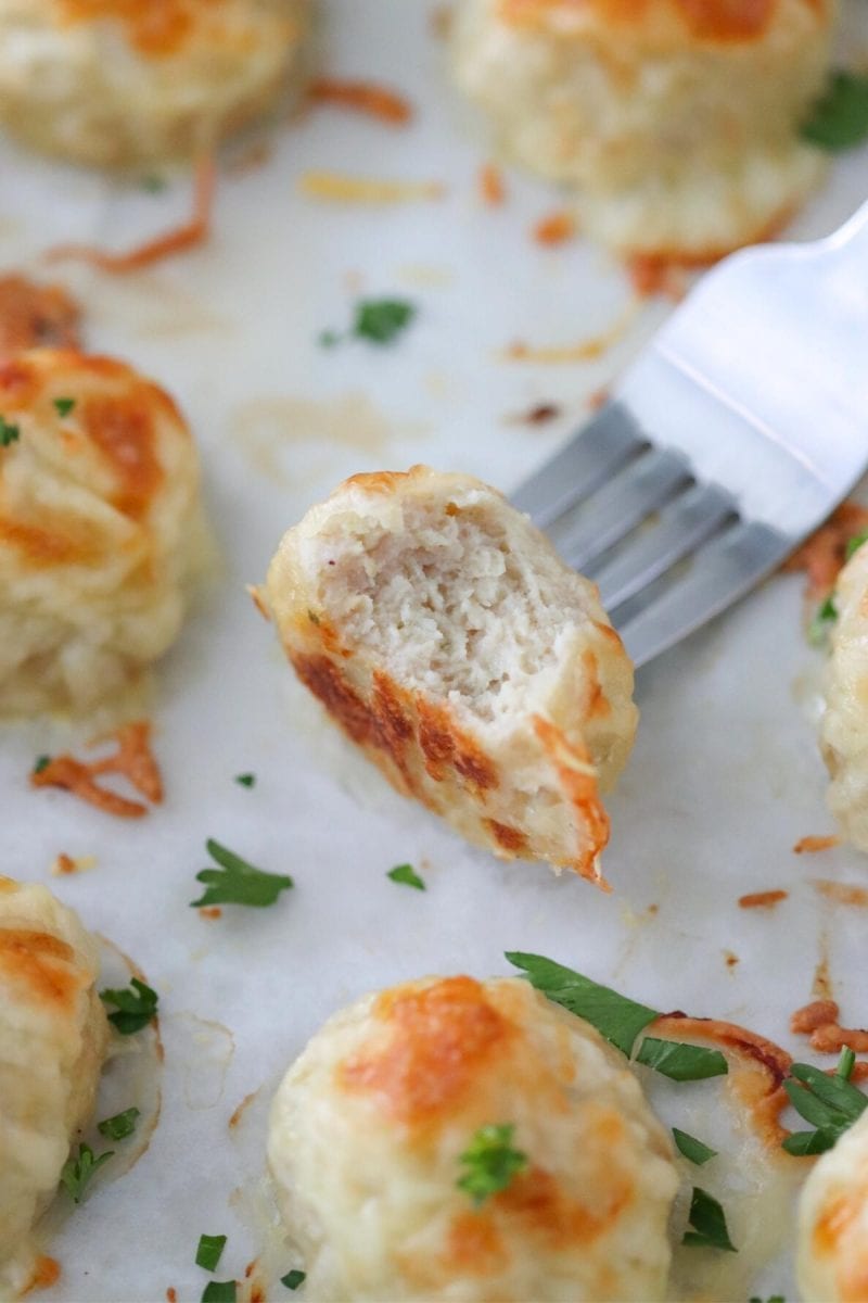 Juicy baked chicken meatballs with a cheesy topping. 