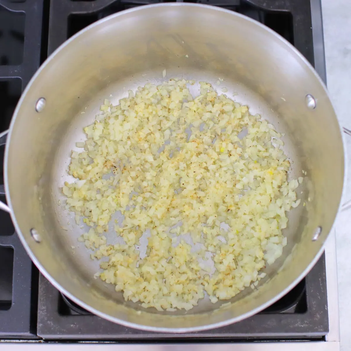 Onions and garlic sauteing in a pot. 