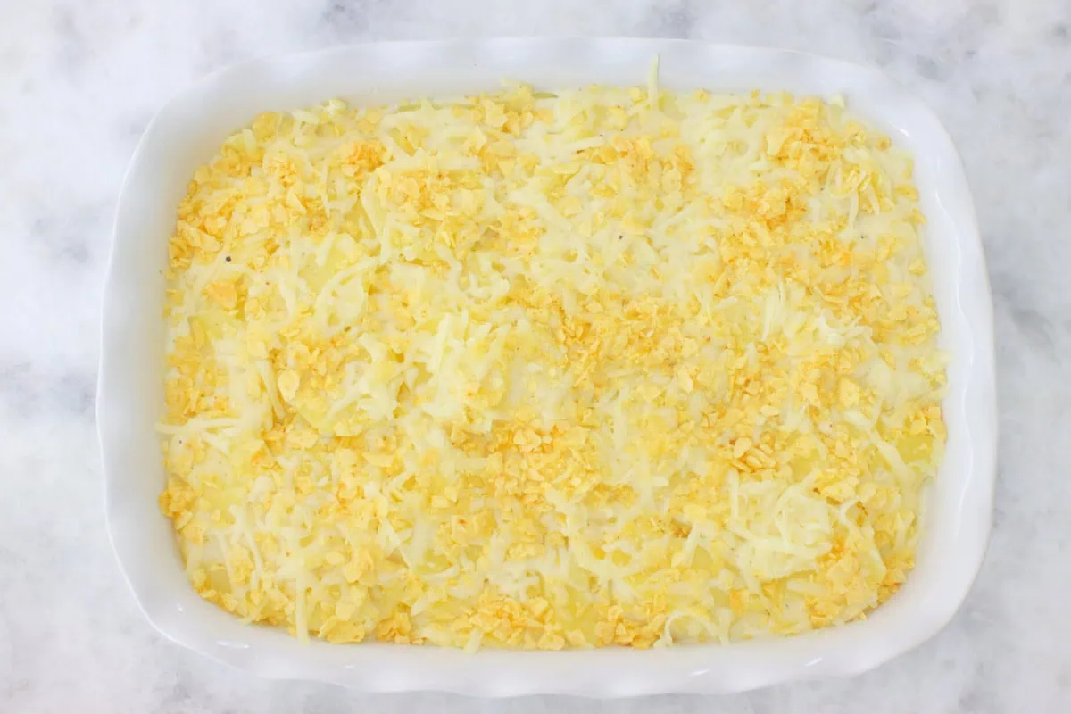 Scalloped potatoes in a baking dish, topped with cheese and crushed potato chips. 
