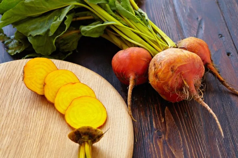 What are golden beets? 
Whole golden beets and a sliced golden beet on a cutting board. 