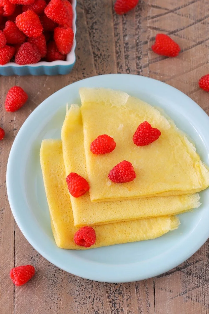 Sourdough crepes in on a plate with fresh raspberries