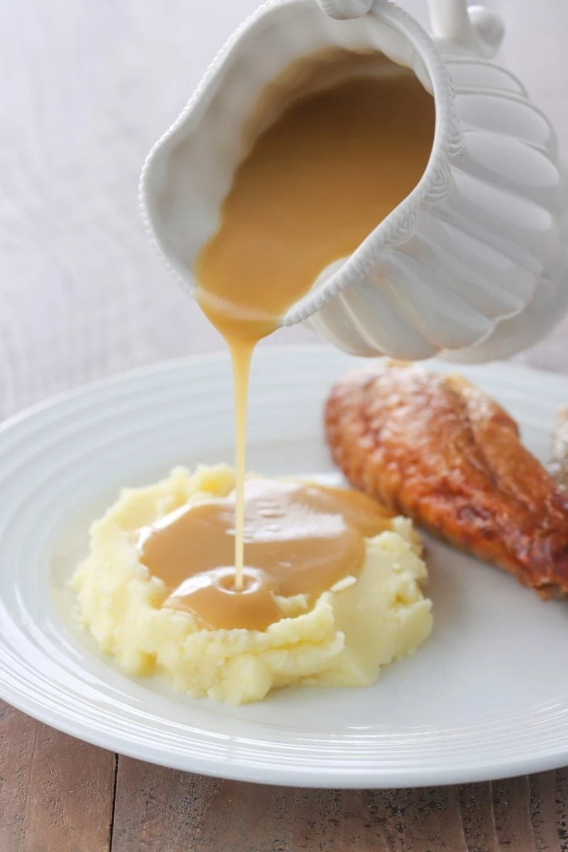 The Best Turkey Gravy poured over mashed potatoes
