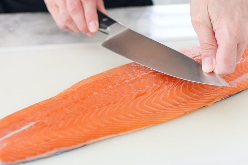 Removing skin from salmon with a sharp knife