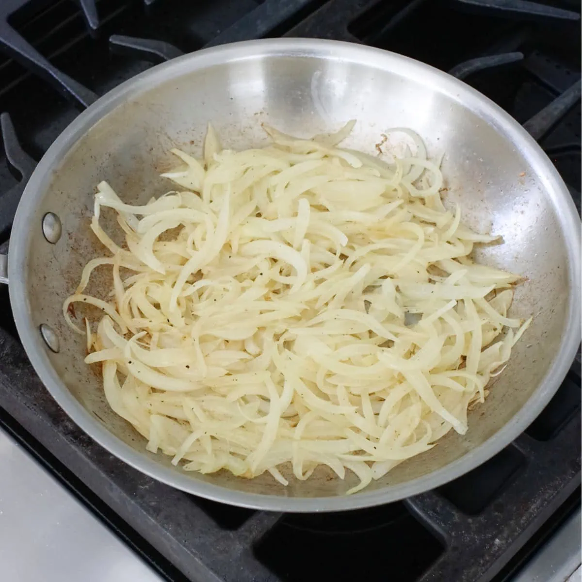 Sliced onions cooking in a pan. 