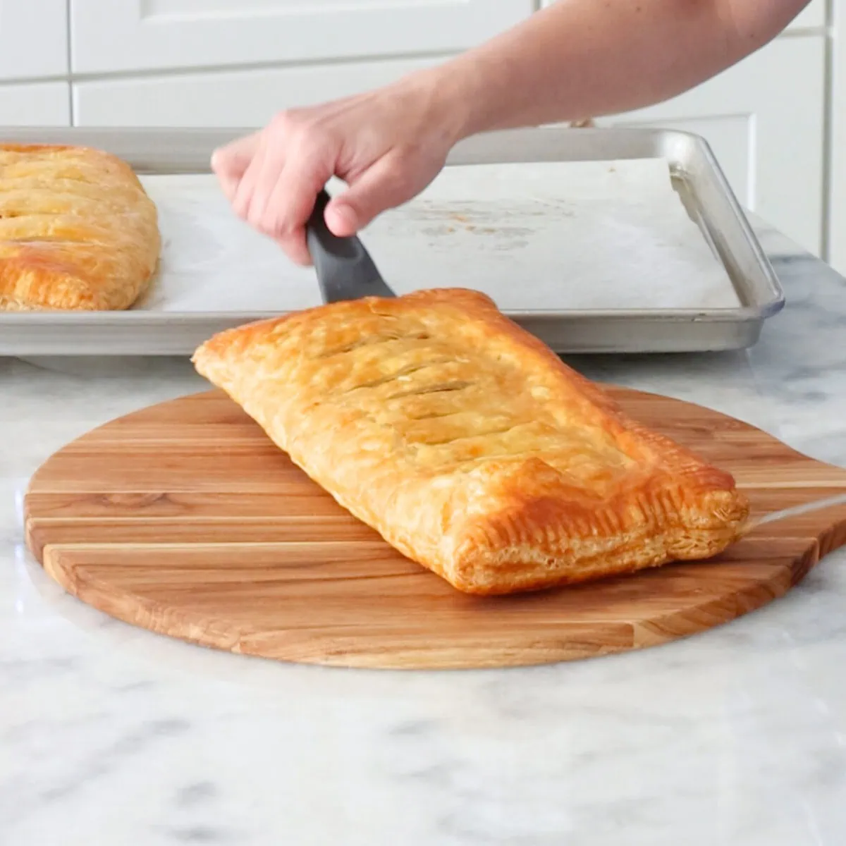 Potato pastry baked golden brown and taken out of the oven from the baking sheet to serving board. 
