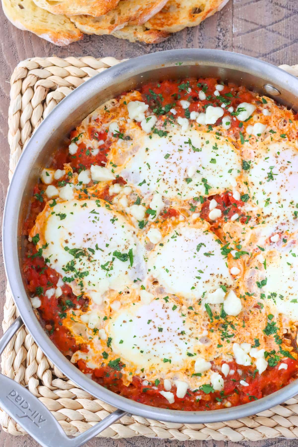 Shakshuka with Fresh Tomatoes, herbs and cotija/feta cheese in a skillet. 