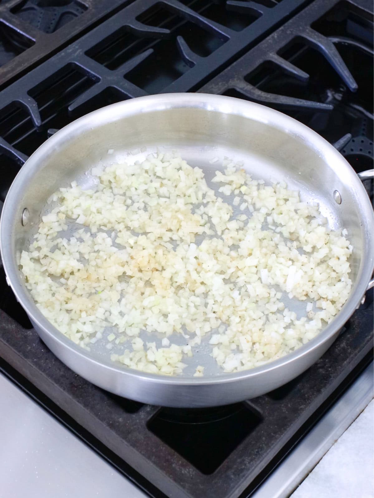 Onions being sauteed in a deep skillet. 