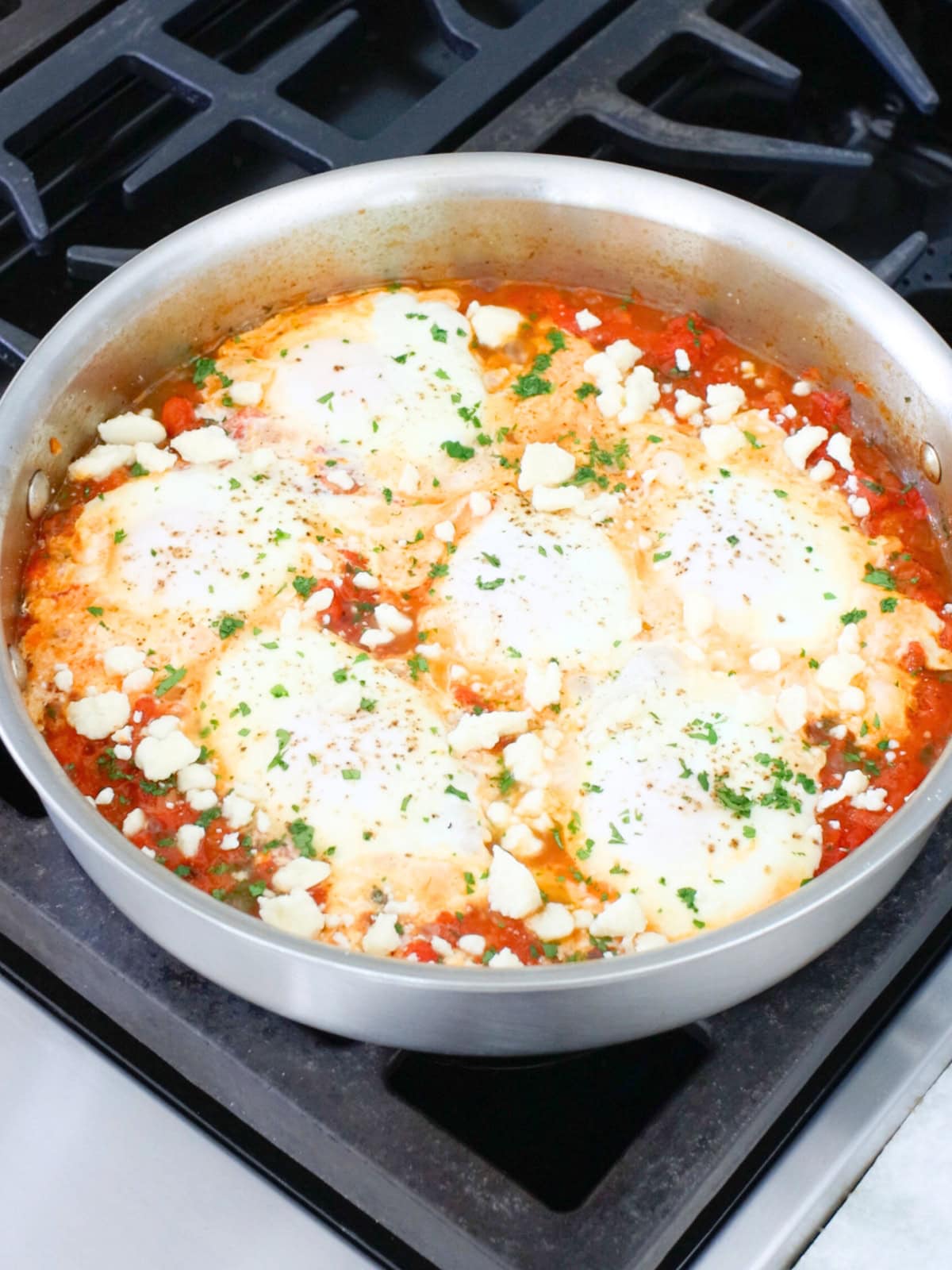 Shakshuka with fresh tomatoes in a deep skillet. 