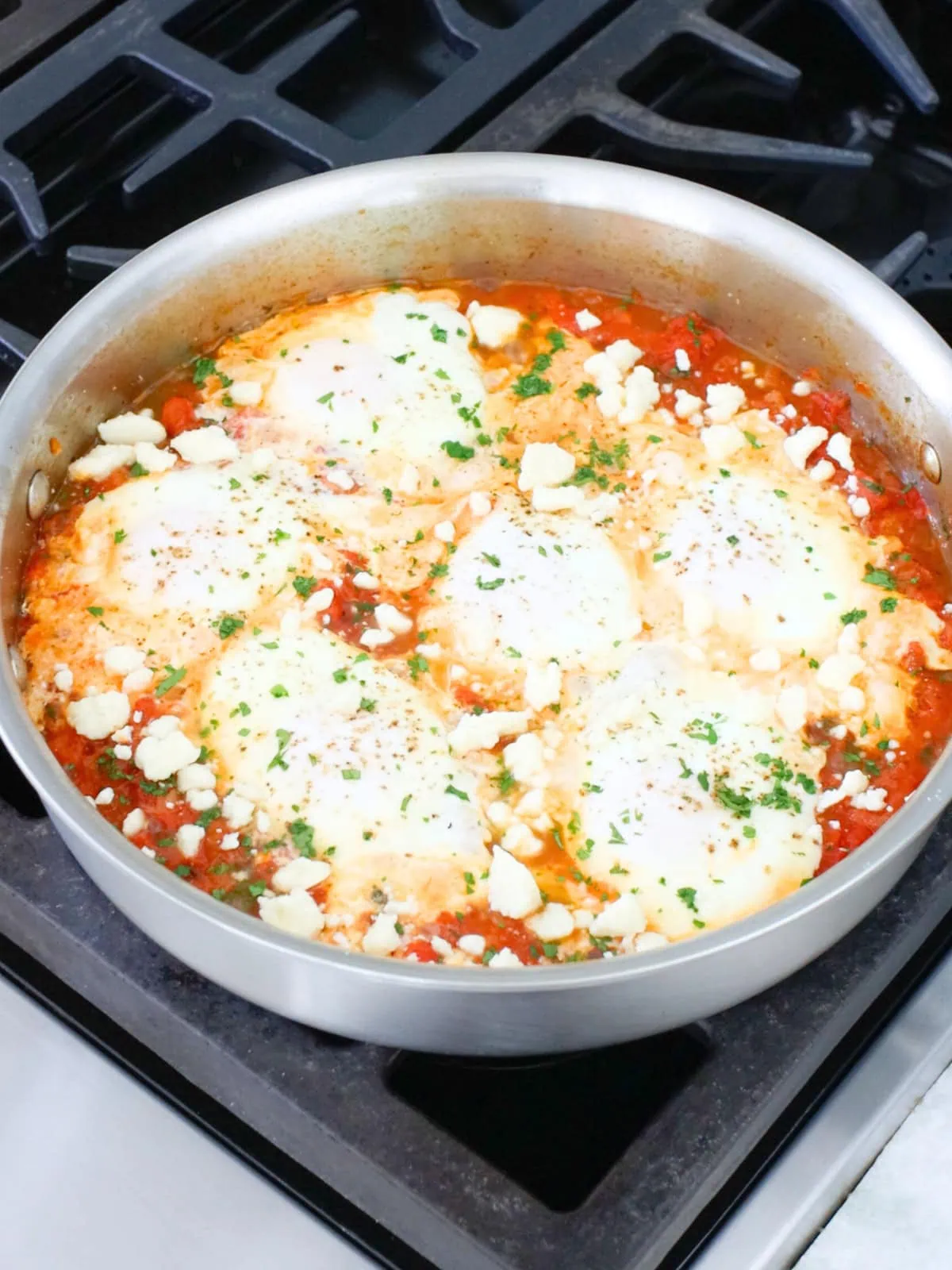 Shakshuka with fresh tomatoes in a deep skillet. 